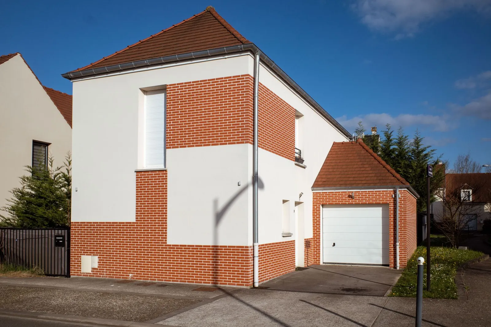Maison avec façade claire et parement en brique